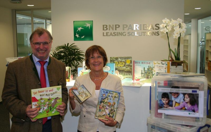 Rudolf Bünten von der BNP Paribas Leasing Solutions in Köln übergibt die Bücherboxen an Barbara Zaabe